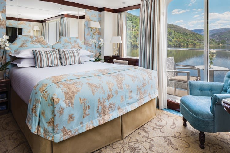 Luxurious river cruise cabin with a private balcony and stunning views.